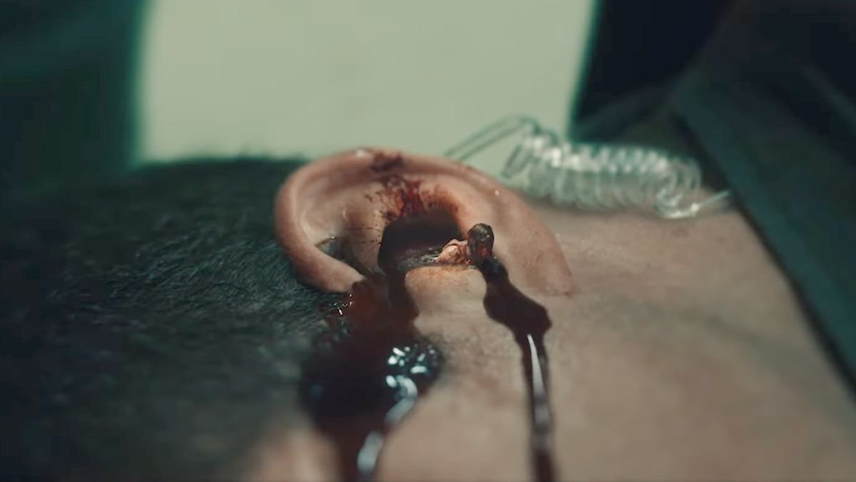 a tiny supe crawls out of a man's ear in Gen V trailer