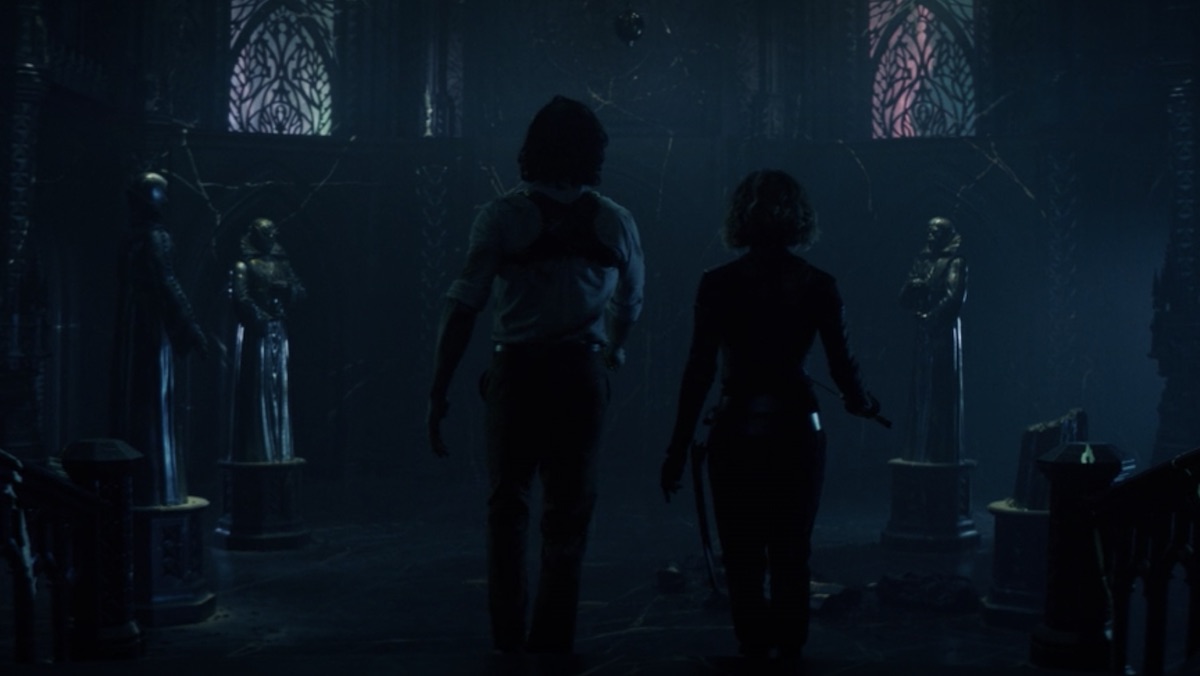 Loki and Sylvie walk into the Citadel's atrium which has three standing statues and one broken one on the floor